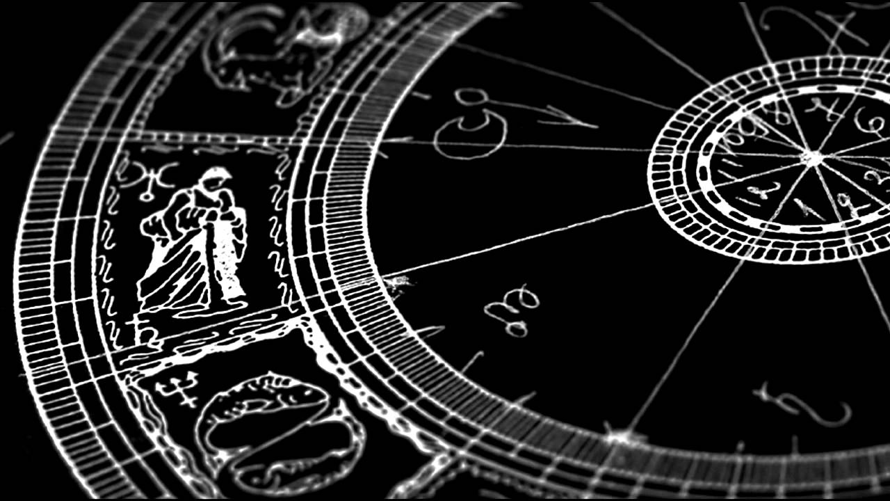 A black-and-white, close-up shot of an intricate astrological or astronomical diagram. The image features hand-drawn style illustrations of zodiac signs, including Aquarius and Pisces, along with various geometric lines, symbols, and a smaller central dial, all rendered in a white-on-black sketch style with a shallow depth of field.